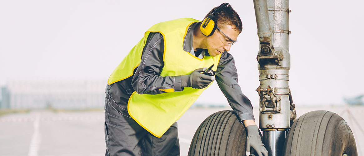 worker inspecting landing gear